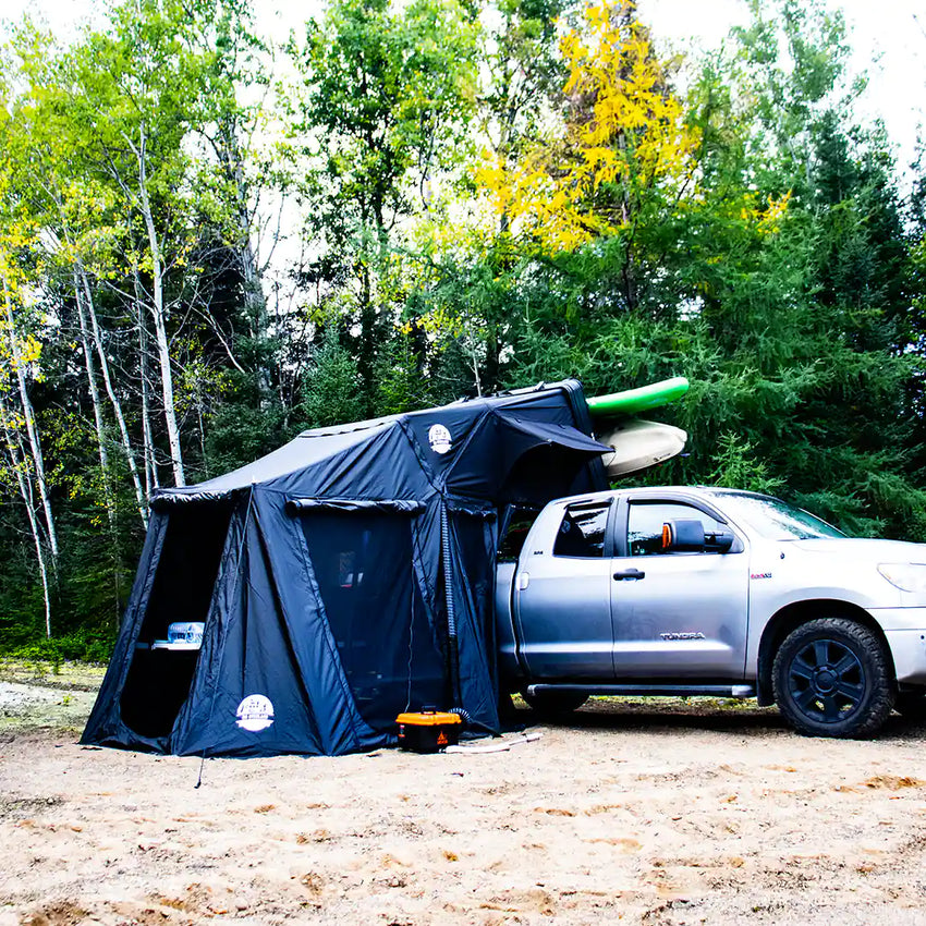 Vue éloignée d'un camping avec une tente de toit et le chauffage au diesel