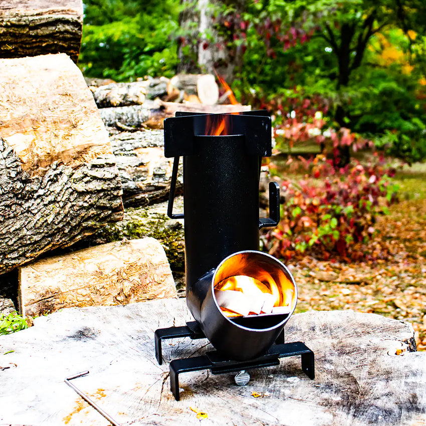 Vue du réchaud à bois de camping avec flamme et bois en combustion