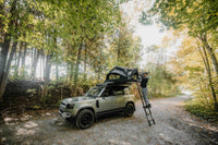 Vue large de la tente de toit avec échelle ouverte sur un land rover
