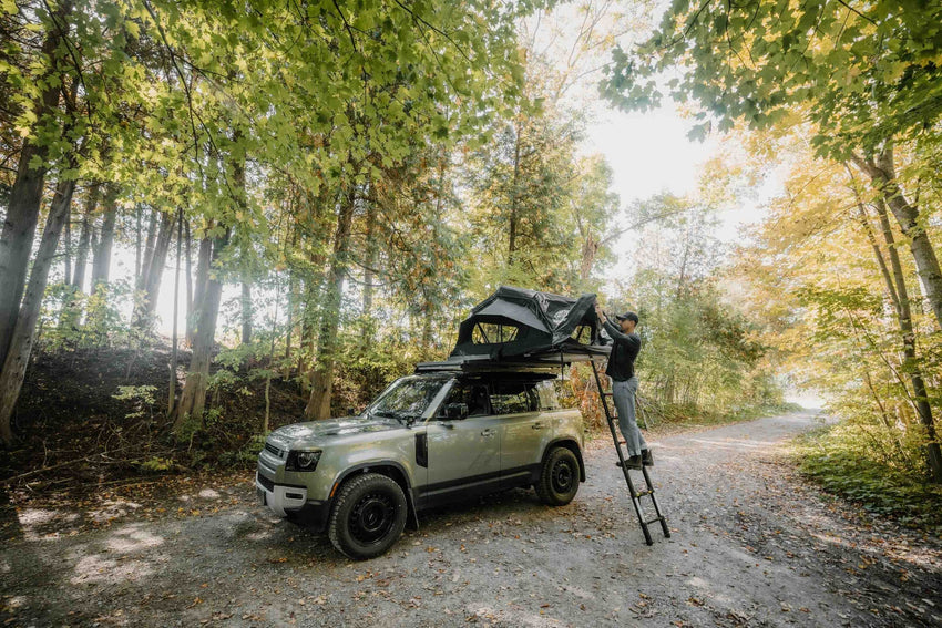 Vue large de la tente de toit avec échelle ouverte sur un land rover