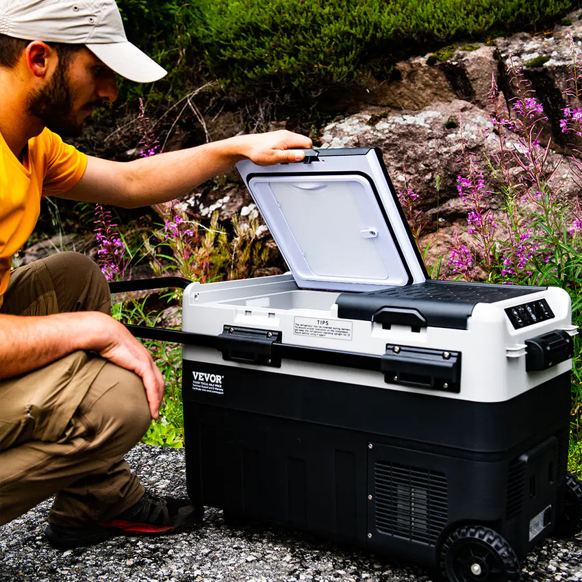 Vue de la glacière électrique portable avec roulettes ouverte en cours d'utilisation