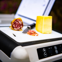 Glacière électrique à roulettes avec saucisson et fromage