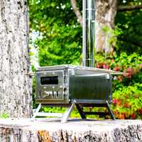 Mini poêle à bois portable en inox installé dans la forêt